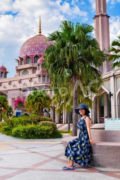 マレーシアのピンク色のイスラム寺院を背景にした日本人観光客の女性 マレーシア,イスラム寺院,観光の写真素材