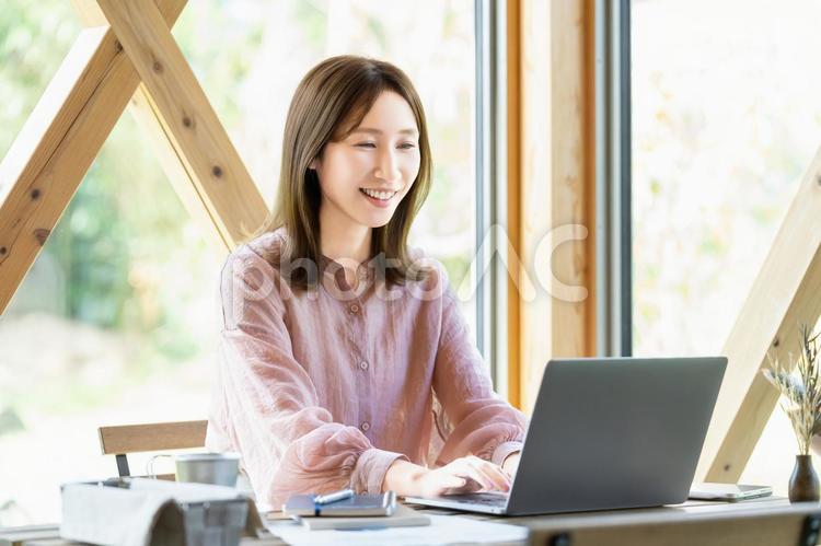 カフェでパソコンを使って仕事をする女性 女性,パソコン,ノートパソコンの写真素材