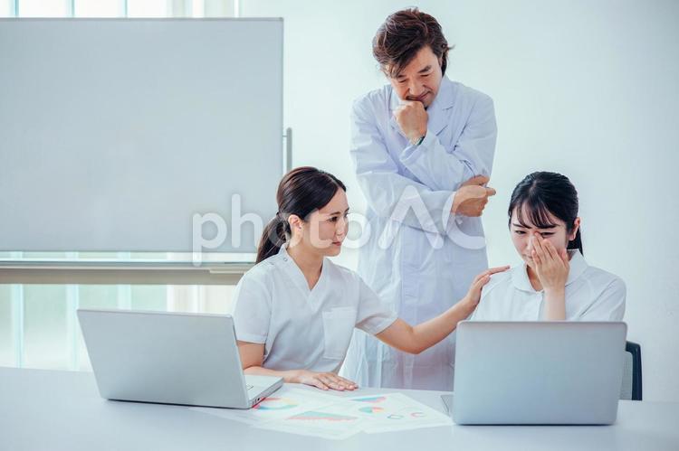 泣く看護師を励ます医者とナース 看護師,泣く,激務の写真素材