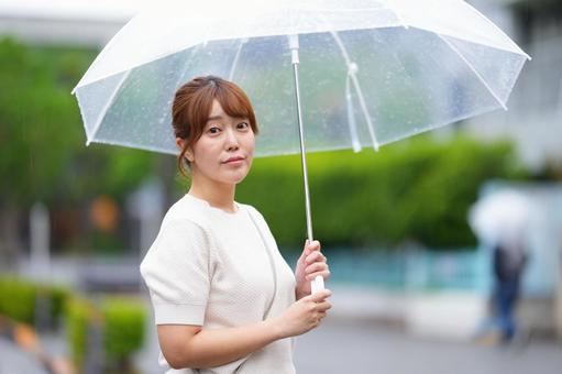 傘を差す真顔の女性の写真