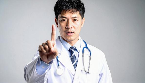 注意! 人差し指を立てる白衣を着た男性 注意! 人差し指を立てる白衣を着た男性の写真