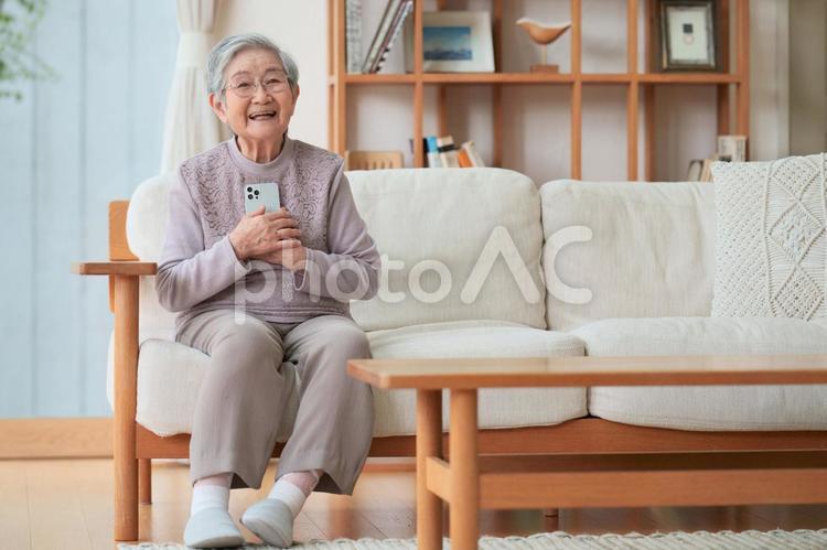 スマホを持ち安心した顔の女性 女性,スマートフォン,持つの写真素材