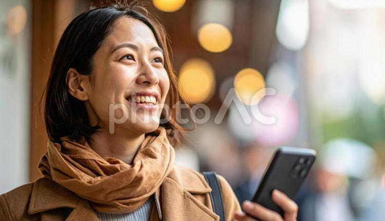 会社帰りにスマホを見るビジネスウーマン アフターファイブ,帰り道,ビジネスウーマンの写真素材
