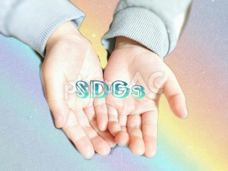 子どもの手のひらの中のSDGs・虹背景 sdgs,社会,エコの写真素材