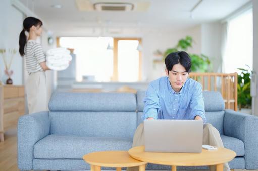 パソコン中の男性とタオルを運ぶ女性の写真