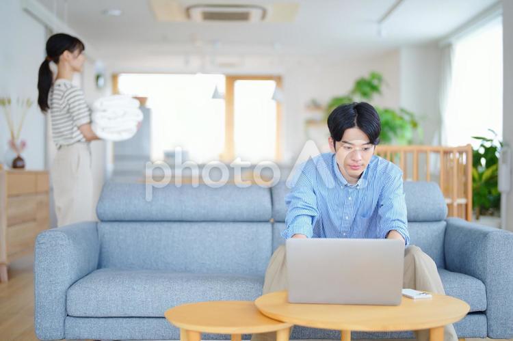 パソコン中の男性とタオルを運ぶ女性 男女,ノートパソコン,真顔の写真素材