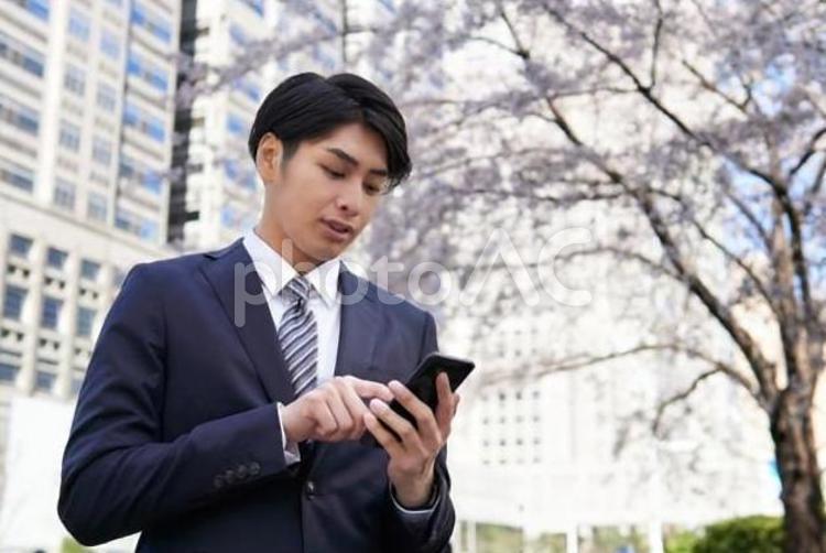 スマートフォンを操作するビジネスマン ビジネスマン,男性,新入社員の写真素材