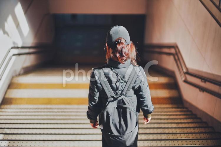 駅の階段を降りる女性の後ろ姿 駅,人物,女性の写真素材