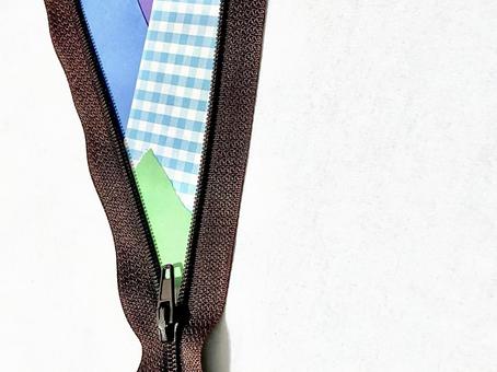 ジッパーの隙間から見えるカラフルな紙 ジッパーの隙間から見えるカラフルな紙の写真