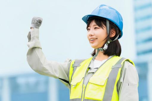 ガッツポーズをする作業服の若い女性 ガッツポーズをする作業服の若い女性 女性,ビジネス,作業服の写真素材