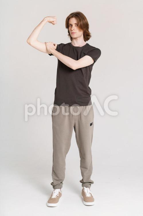 力こぶを触る長髪の男性 男性,力こぶ,触るの写真素材