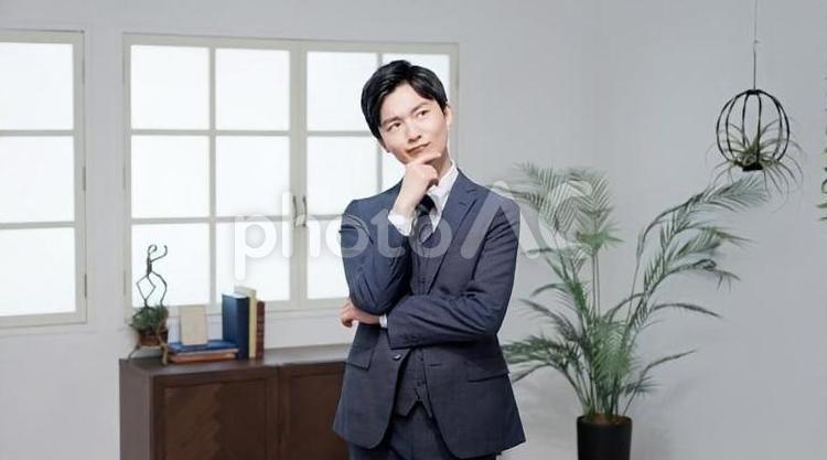 考え込むアジア人ビジネスマン	 ビジネスマン,男性,考えるの写真素材