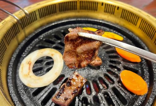 トングでつかんだ牛肉 トングでつかんだ牛肉の写真
