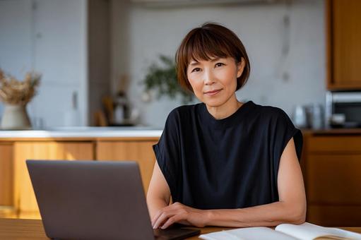 自宅でパソコン作業をする50代女性2 自宅でパソコン作業をする50代女性2の写真