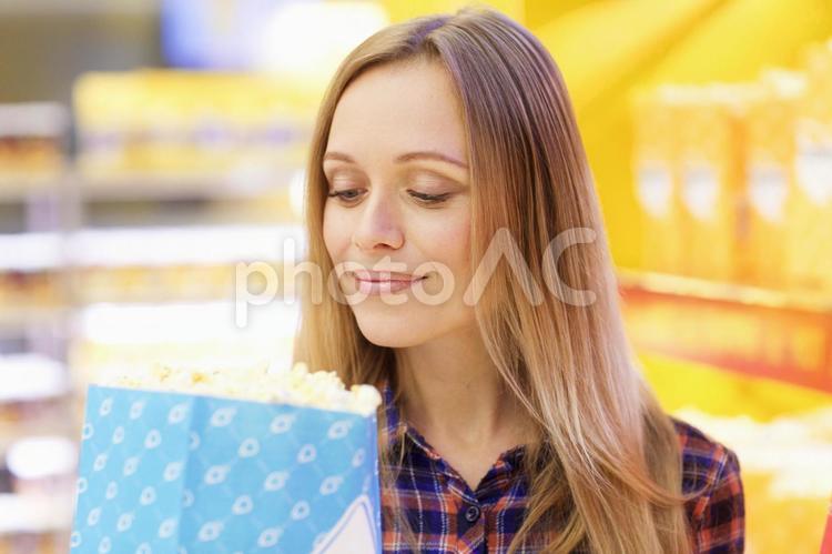 映画館のロビーでポップコーンを持っている女性8 映画館,売店,女性の写真素材
