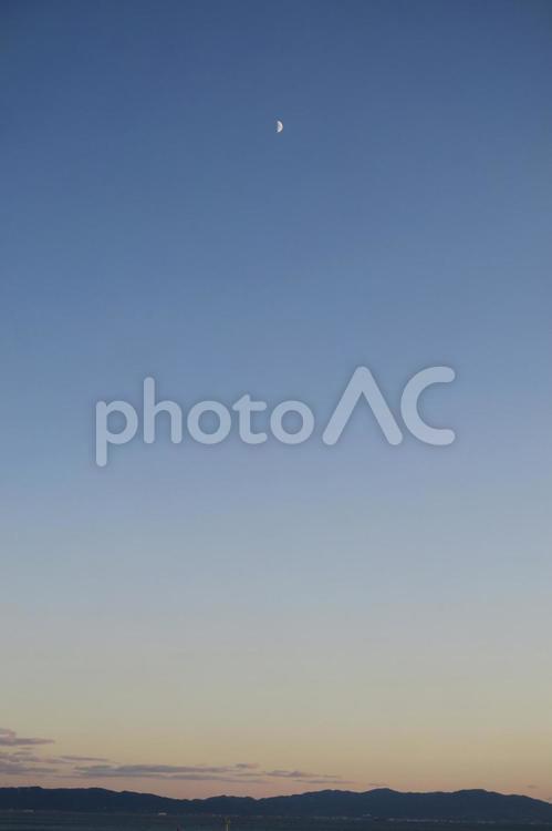 海の上に浮かぶ月 月,半月,夕方の写真素材