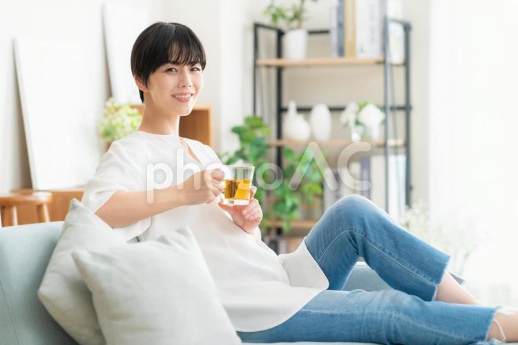 リビングでお茶を飲む若い女性 女性,ティータイム,お茶の写真素材