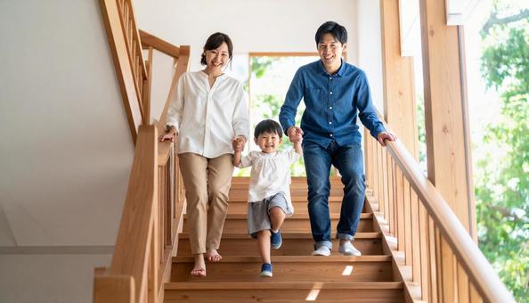 階段を下りるのが楽しい子供と見守る両親 階段を下りるのが楽しい子供と見守る両親の写真