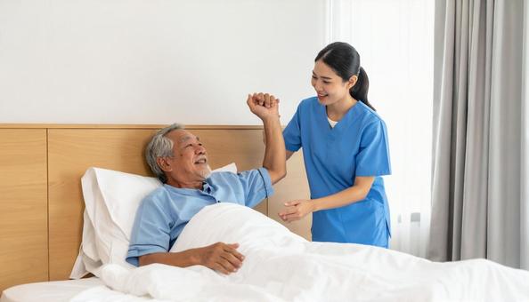 シニアの起き上がりを補助する介護士 シニアの起き上がりを補助する介護士の写真