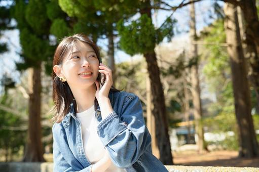 公園で電話をする女性 公園で電話をする女性 スマホ,女性,ビジネスの写真素材