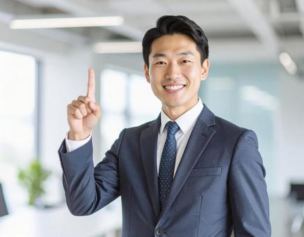 自信満々に指を立てて提案するビジネスマンの写真
