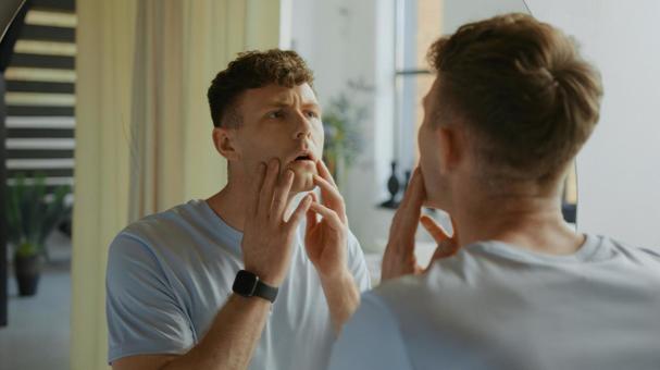 鏡で自分の顔をチェックしている男性 男性,外国人,欧米人の写真素材