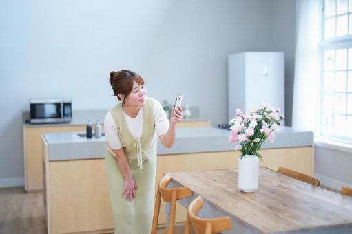 スマホで花を撮影する女性 女性,花,花瓶の写真素材