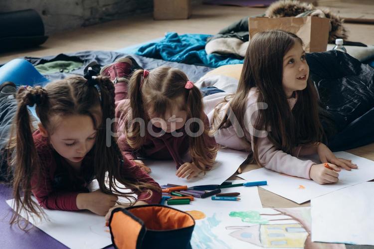 お絵描きしながら見上げる女の子 女の子,人物,貧困の写真素材