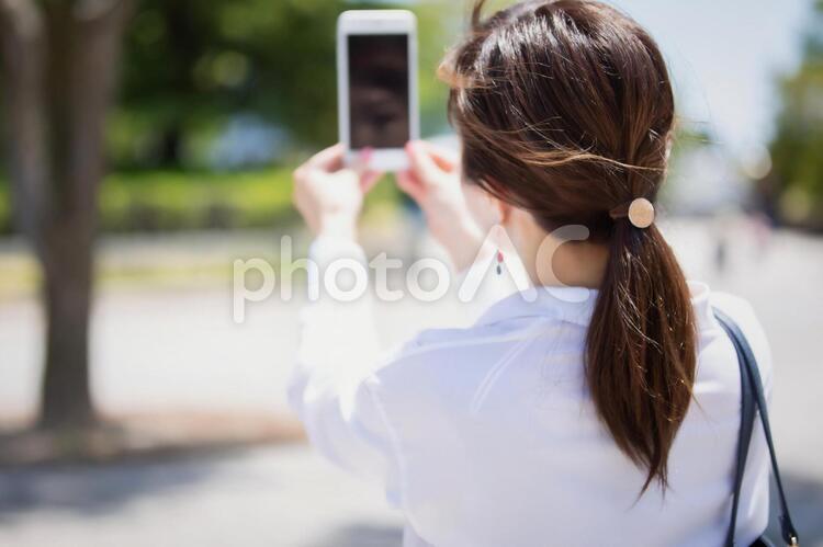スマホを持って撮影する女性 自撮り,セルフィー,女性の写真素材