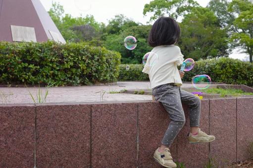 公園でシャボン玉遊びをする女の子 公園でシャボン玉遊びをする女の子の写真