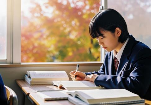 秋の教室で勉強に集中する女子学生の写真