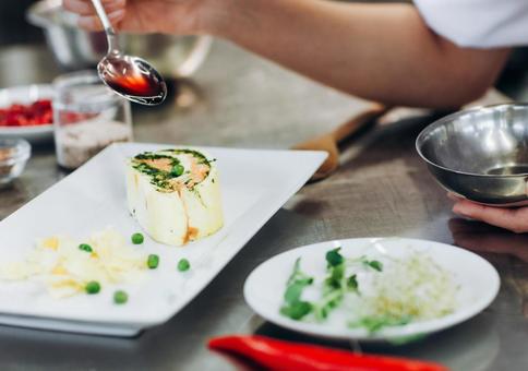 料理を仕上げる女性シェフの手元 料理を仕上げる女性シェフの手元 キュイジーヌ,キッチン,厨房の写真素材