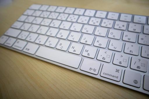 木目のデスクに置かれた白いキーボード 木目のデスクに置かれた白いキーボード キーボード,パソコン,デスクの写真素材