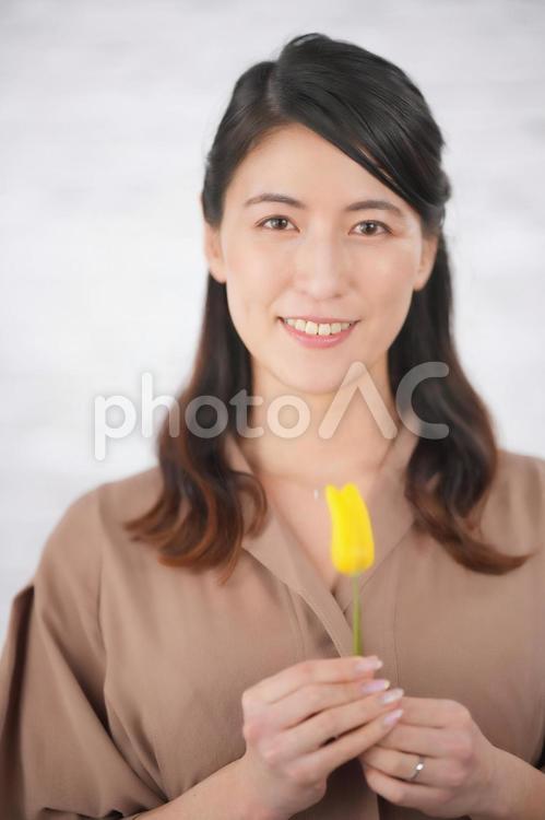 黄色のお花を一輪持った女性 女性,妻,父の日の写真素材