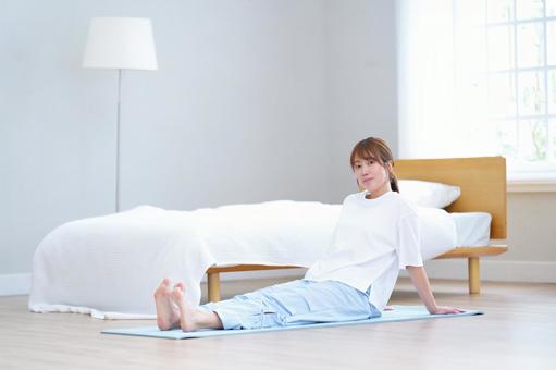 カメラ目線でヨガマットに座っている女性 女性,座る,微笑むの写真素材