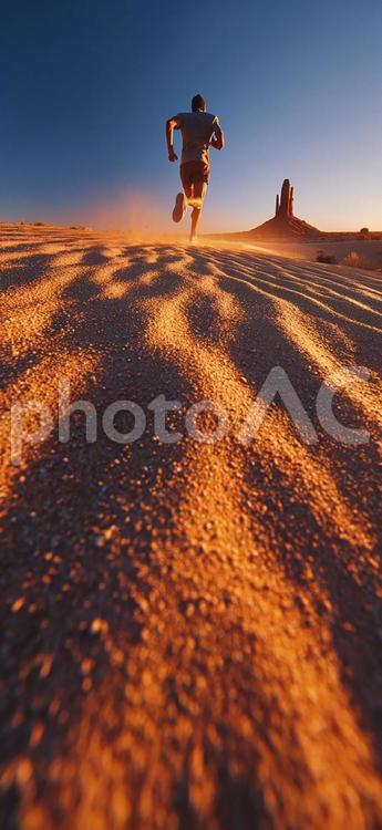 夕焼けの砂漠を走る決意に満ちたランナー 砂漠,ランナー,男性の写真素材