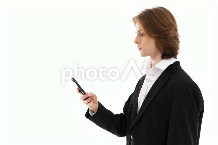 スマホを見る外国人男性の横顔 男性,スマートフォン,持つの写真素材