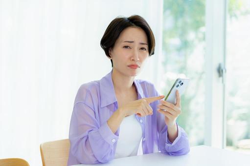 スマホを持って考える女性 スマホを持って考える女性 スマホ,考える,悩むの写真素材