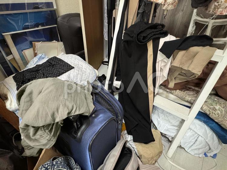 散らかった女性の部屋洋服やキャリーバッグ 洋服,衣類,衣替えの写真素材