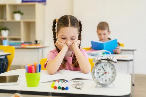 ノートを読む男の子と頬杖をつく女の子 男の子,女の子,子どもの写真素材