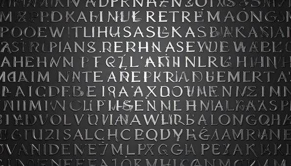 黒色の壁に刻まれた銀色の文字の写真