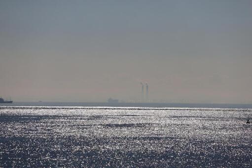 光る海面の海と霞む空と船と街並み 光る,海面,海の写真素材