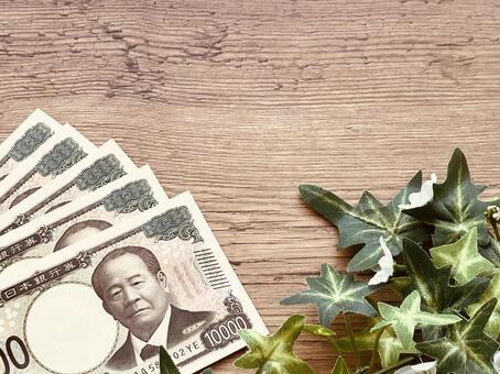 木目調のデスクの上に置かれた現金5万円 １万円,紙幣,お金の写真素材