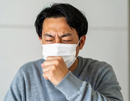 マスクを着用して咳をするの男性 マスクを着用して咳をするの男性の写真