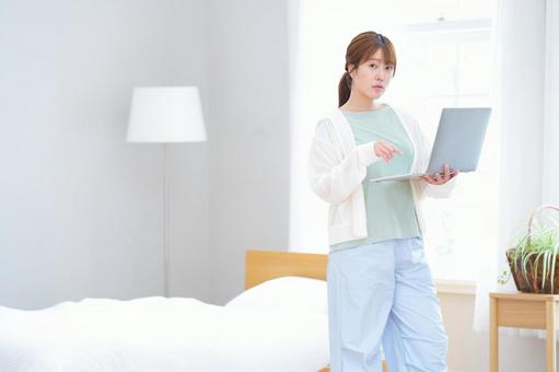 パソコンを持ちカメラ目線の女性 女性,ノートパソコン,持つの写真素材