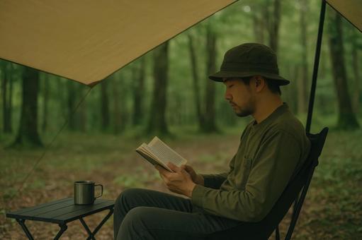 タープ下で読書を楽しむ男性 タープ下で読書を楽しむ男性の写真