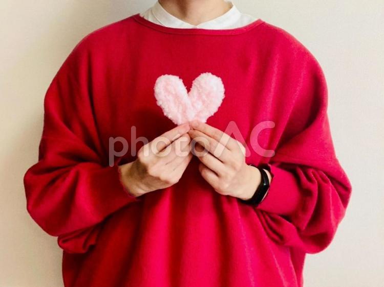 ピンクのハートを持つ赤い服を着た女性 ハート,女性,ケアの写真素材