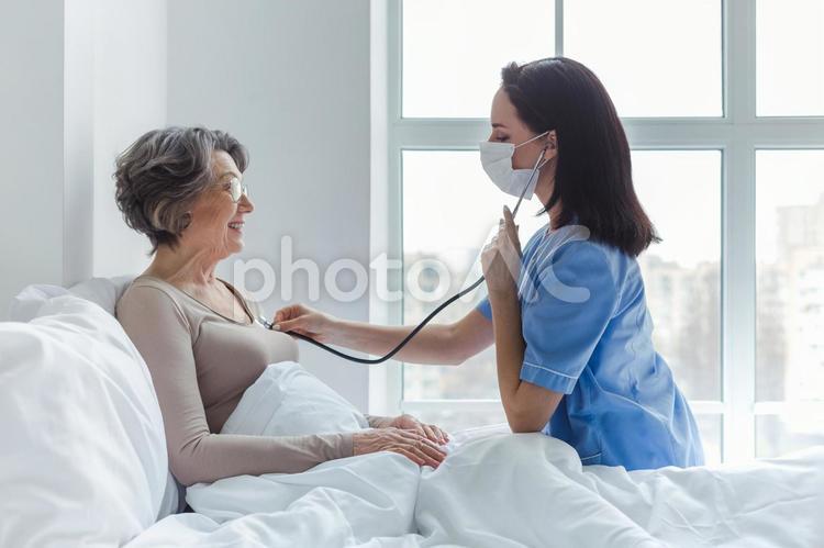 聴診器をあてる女医と笑顔の患者1 女性,女医,患者の写真素材