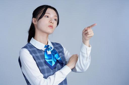 青いリボンの制服の女性が指をさす 女性,指差し,ポーズの写真素材