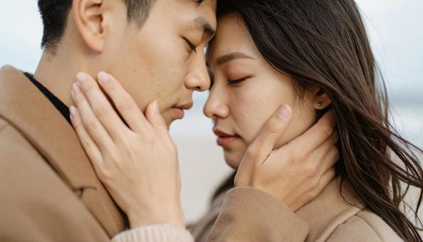 海辺で抱き合うカップルの写真